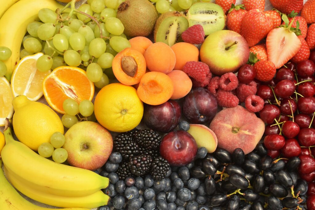 Assorted fresh fruits including grapes, oranges, berries, bananas, kiwis, and peaches arranged for a vibrant get well soon fruit basket or healthy gift hamper in Singapore